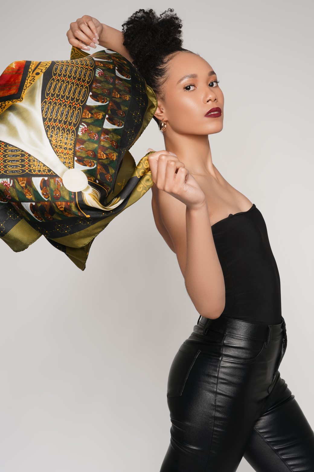 Model holding the green Queen of Sheba scarf in motion