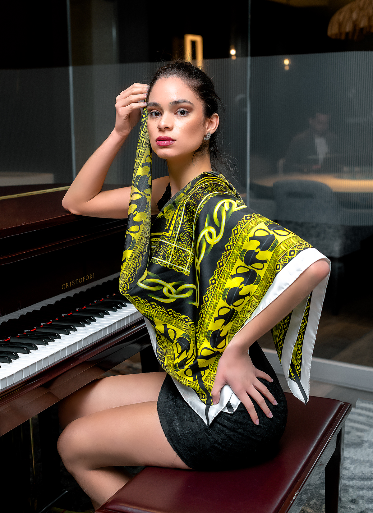 Model seated by a piano wearing the yellow Jebena scarf